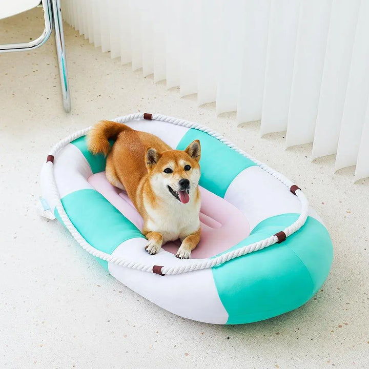 A cooling pet bed with a canoe-shaped design, featuring soft and breathable materials. The bed is in low-saturation summer colors, providing a comfortable, cool resting place for pets during hot weather.