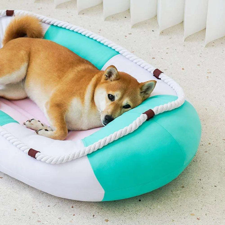 A cooling pet bed with a canoe-shaped design, featuring soft and breathable materials. The bed is in low-saturation summer colors, providing a comfortable, cool resting place for pets during hot weather.