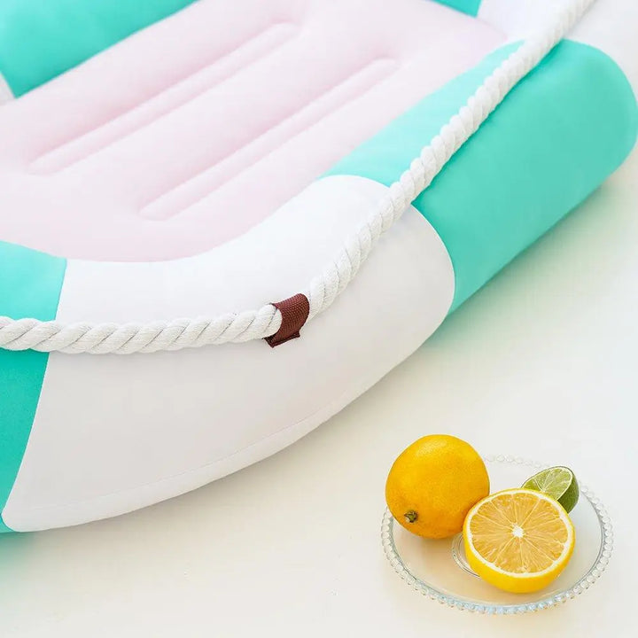 A cooling pet bed with a canoe-shaped design, featuring soft and breathable materials. The bed is in low-saturation summer colors, providing a comfortable, cool resting place for pets during hot weather.