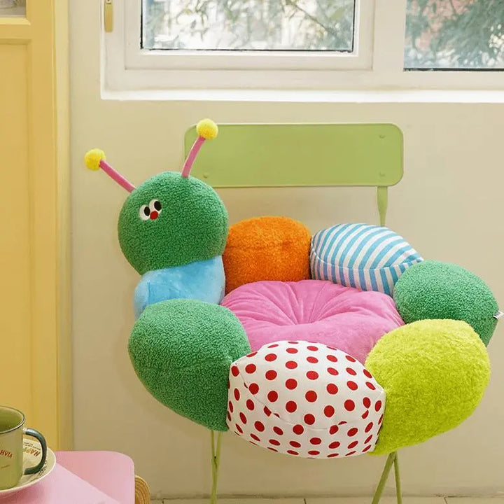 "Green caterpillar-shaped pet bed with colorful details, providing comfort and fun for pets."