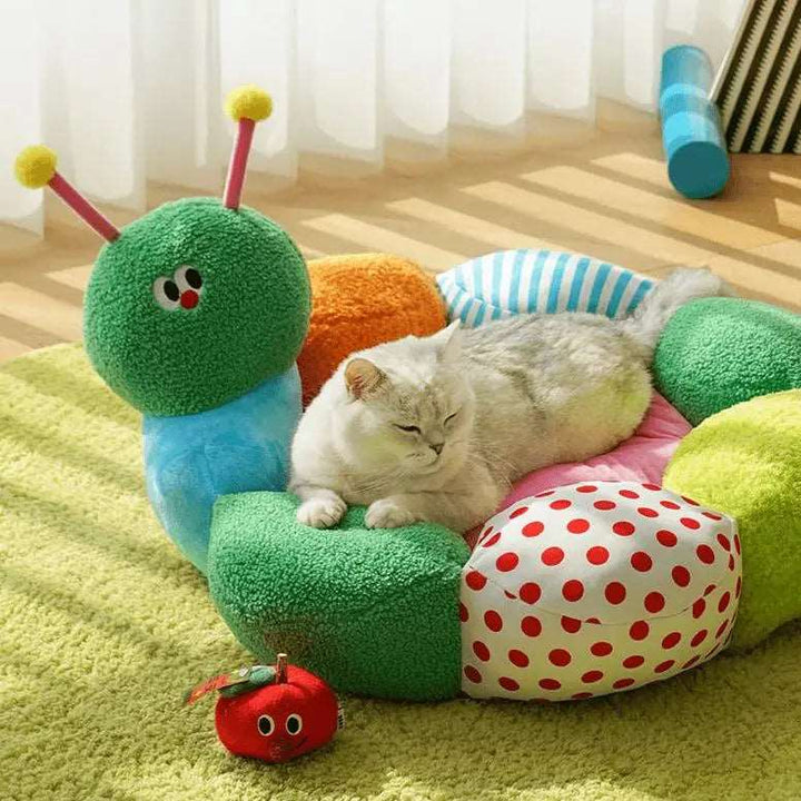 "Green caterpillar-shaped pet bed with colorful details, providing comfort and fun for pets."