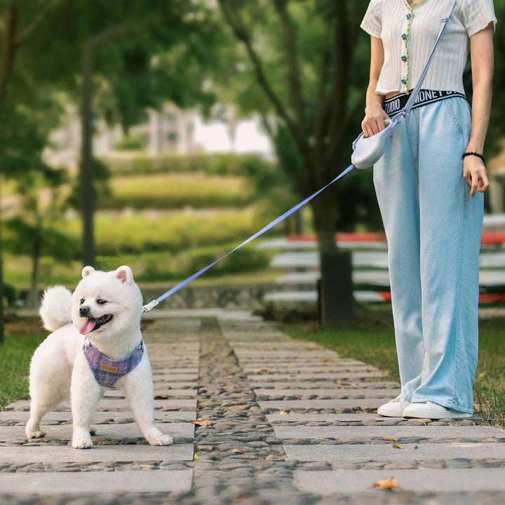 Retractable dog leash with durable build, ergonomic handle, and extra shoulder strap for hands-free control.